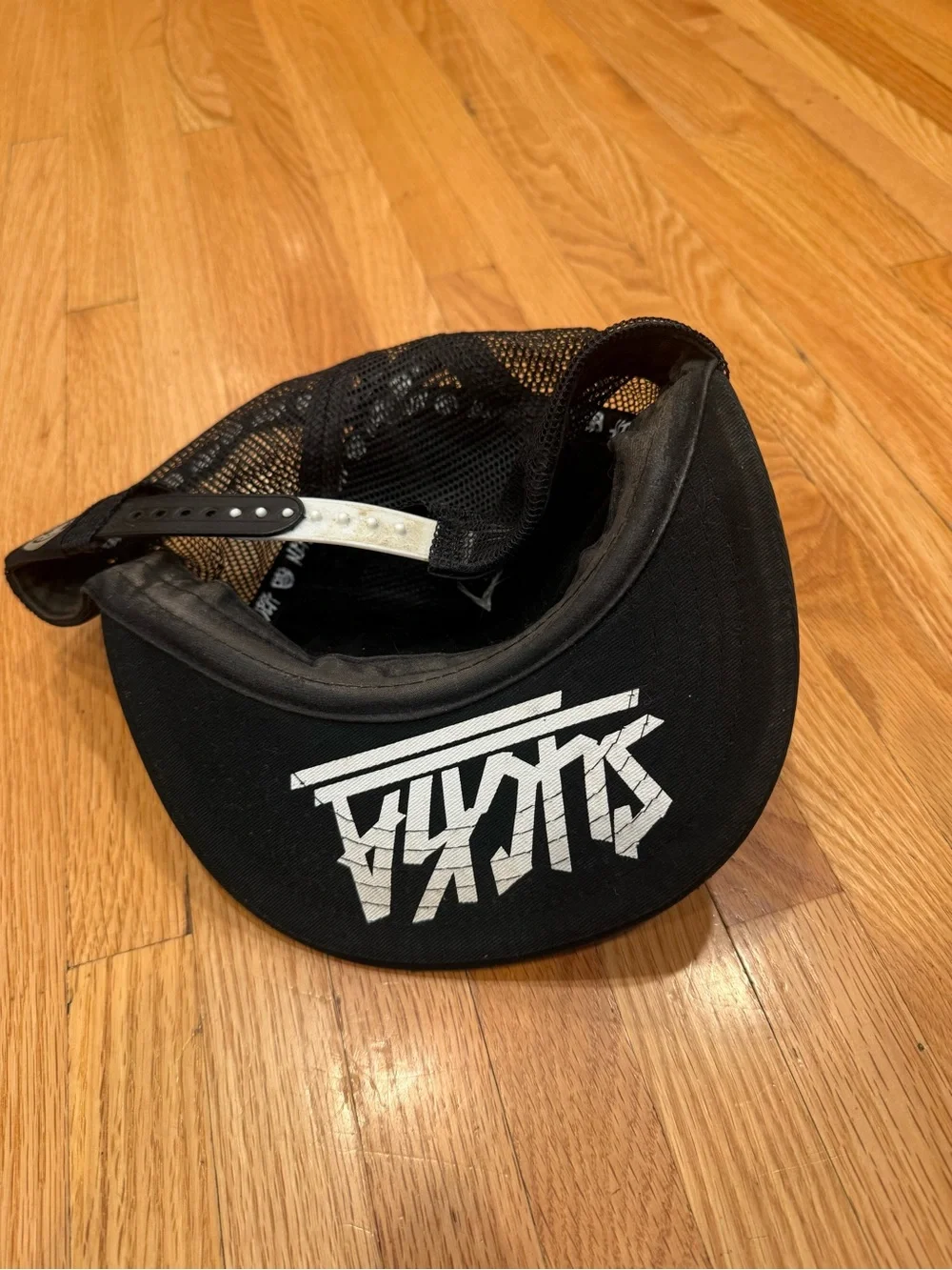 Sucka Character Black Trucker Hat with Playful White Face Graphic